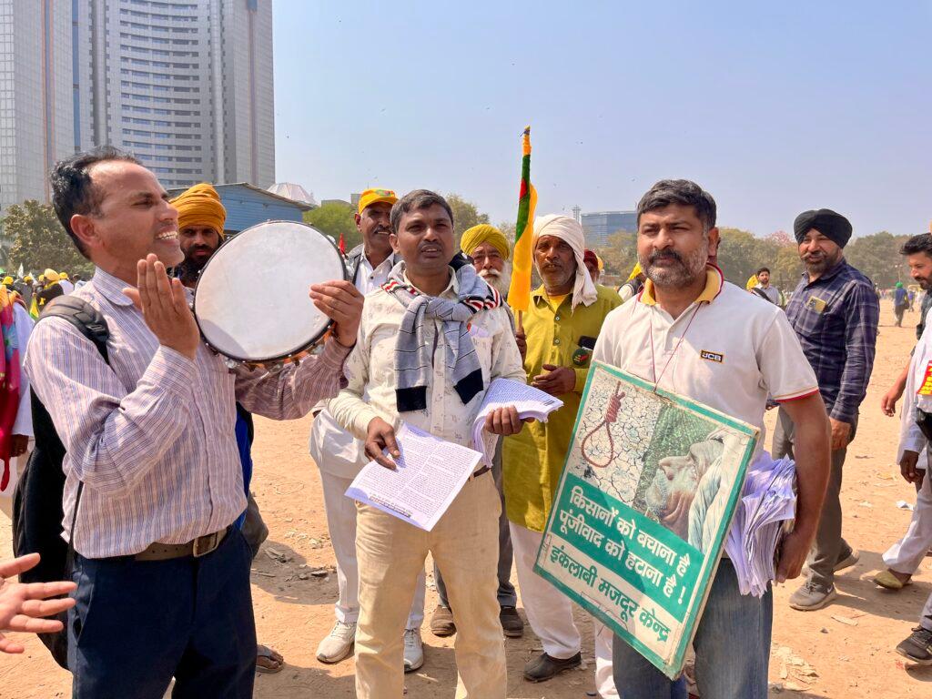 Group of Indian men holding signs and playing the tambourine
