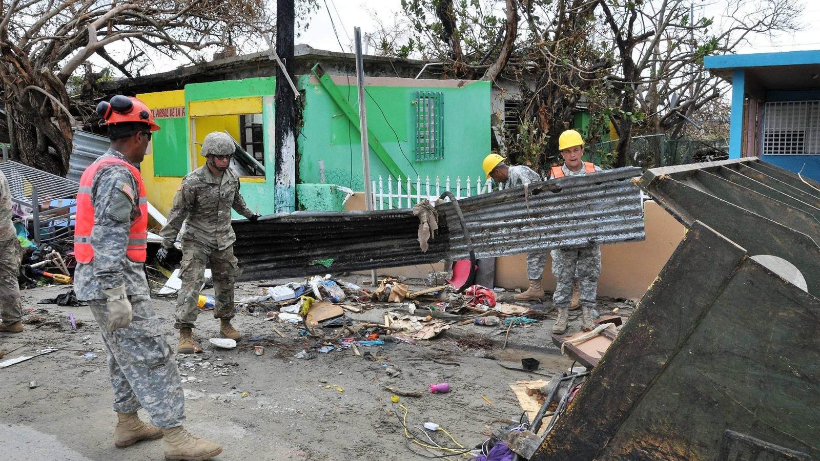 Soldiers of the Puerto Rico National Guard and volunteers of the Puerto Rico State Guard clear a road at Punta Santiago in Humacao, Puerto Rico. Scenes of utter devastation were found throughout the island after Hurricane Maria hit last September.