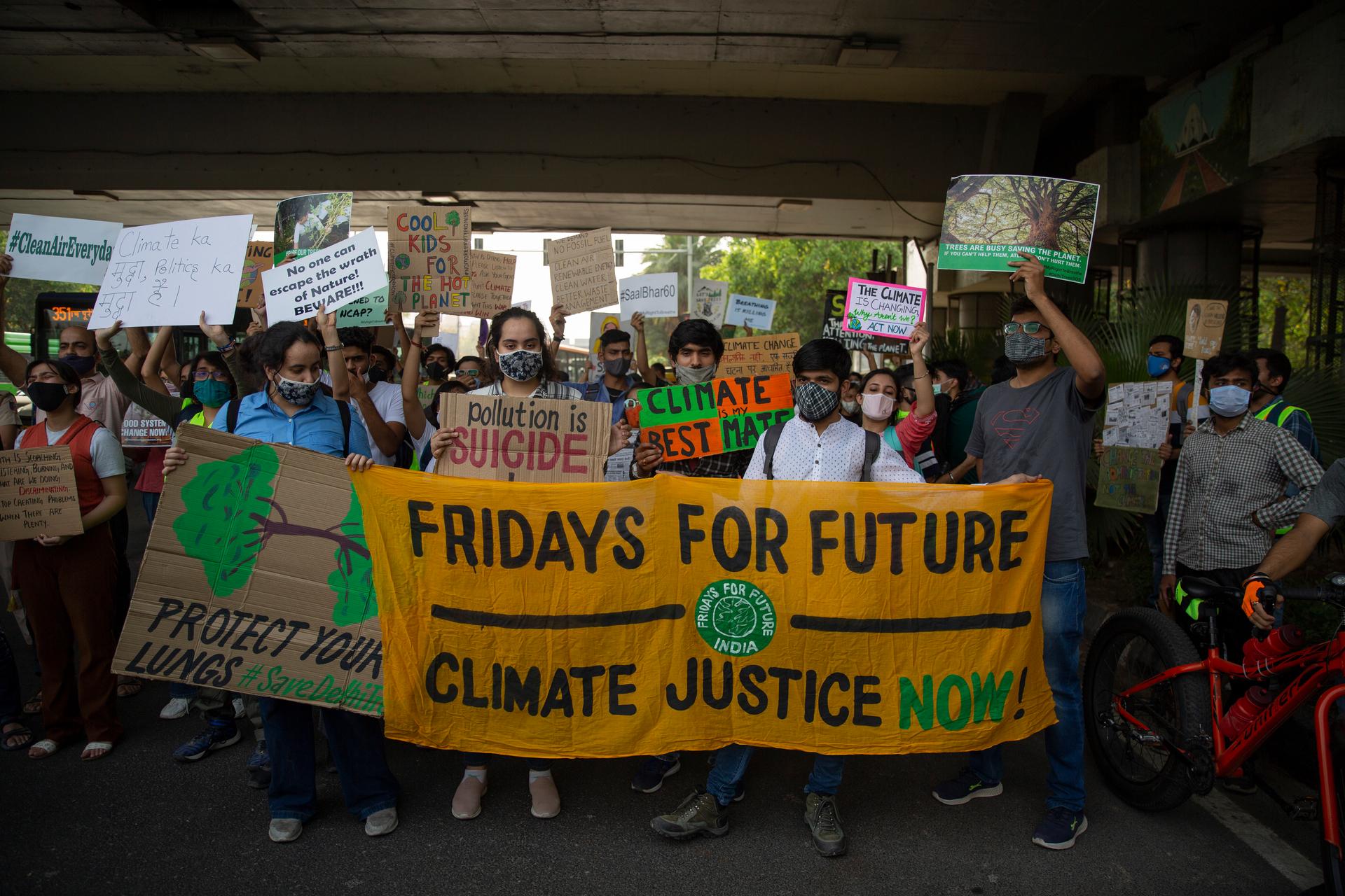Student activists carry posters and shout slogans as they participate in a protest march against climate change in Delhi, India, March 19, 2021.