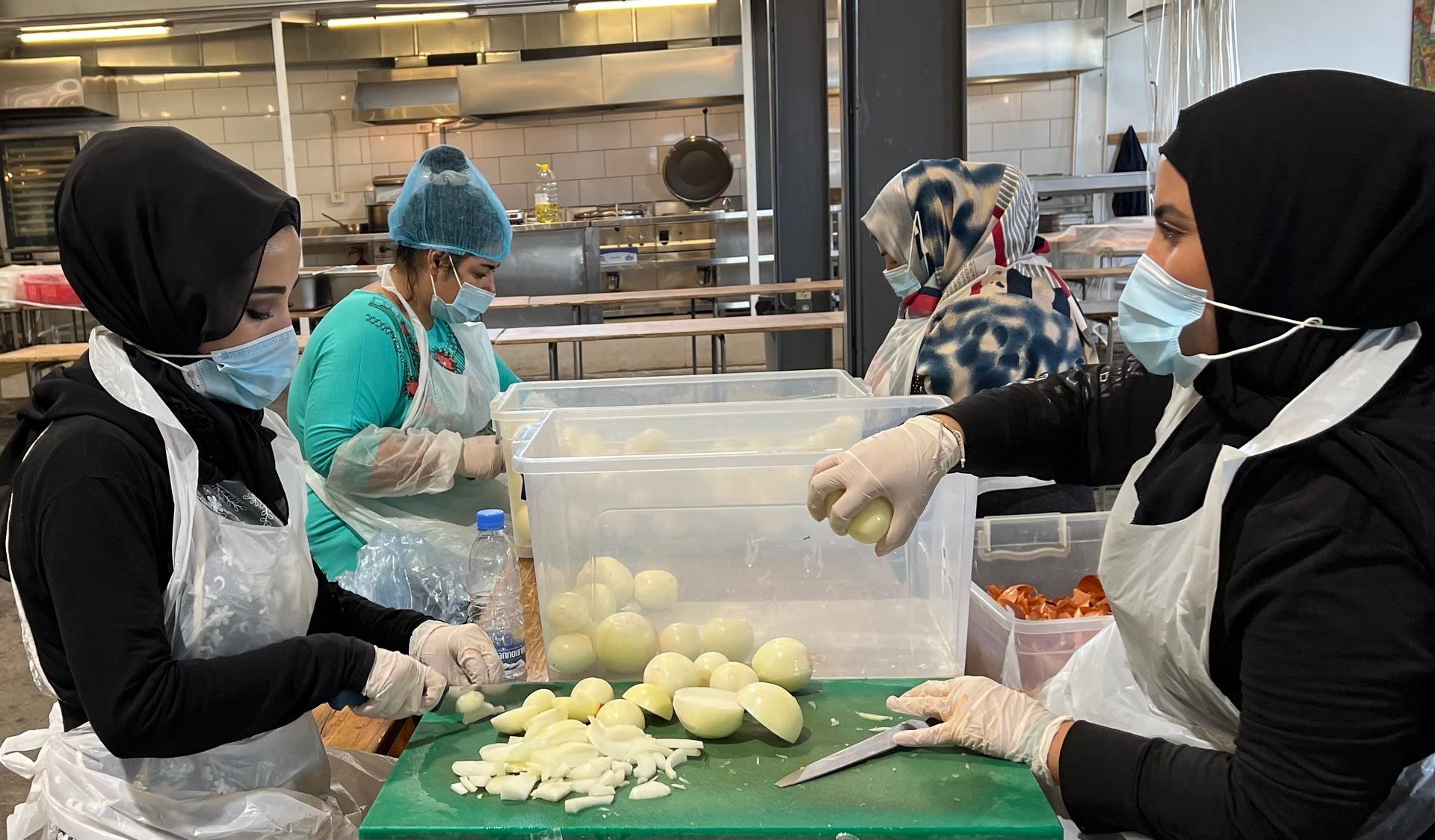 Workers prepare meals at the Matbakh El Kell Community Kitchen in Beirut. The kitchen was set up in response to the Aug. 4 Beirut port explosion, and it now serves 2,500 free meals a day to those in need.