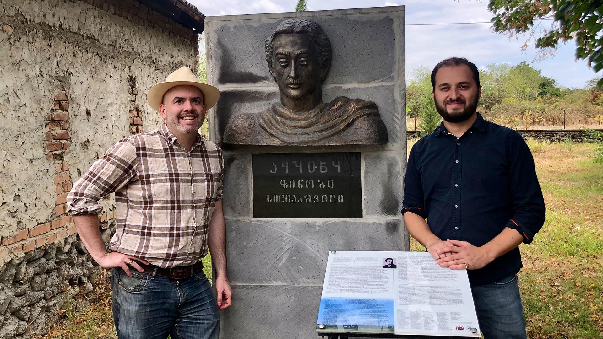 Linguist Thomas Wier and Udi activist Alexander Kavtaradze at a memorial to Zinobi Silikashvili, the founder of the village of Zinobiani, Georgia. The inscription includes both Caucasian Albanian (Udi) and Georgian script.