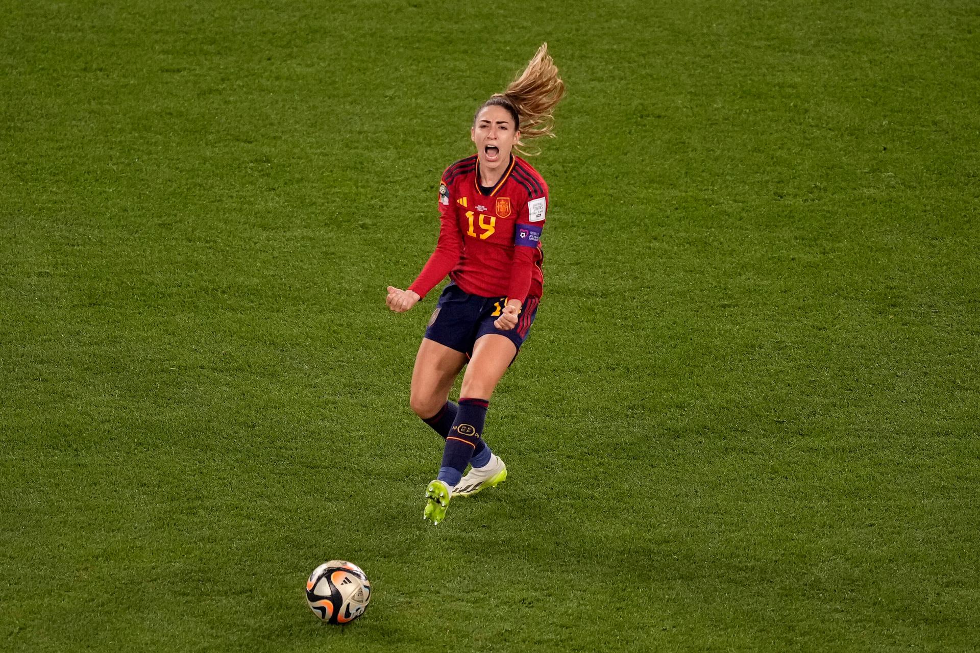 woman in soccer uniform running with ball