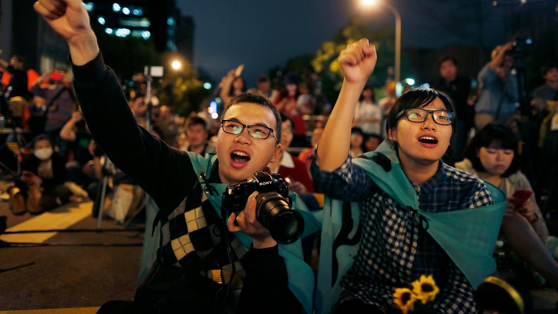 Students cheer on speakers during a gathering to mark the first anniversary of student groups stormed the parliament in Taipei, Taiwan, Wednesday, March 18, 2015. 
