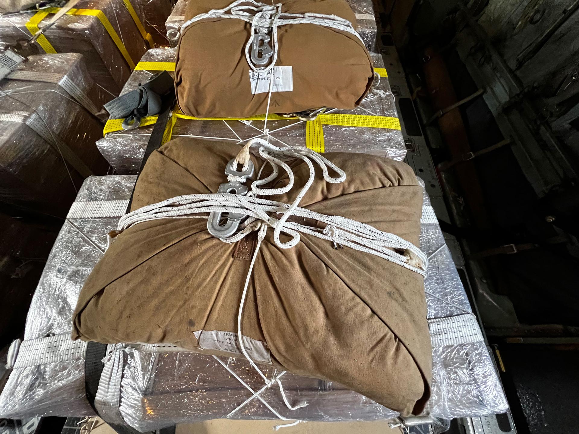 Each pallet of aid is fitted with a parachute which opens as they are dropped.