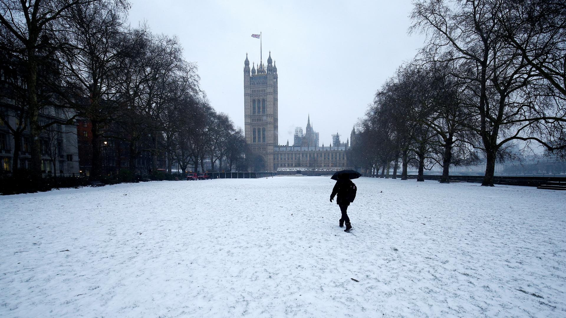 A man walks in the snow next to the Houses of Parliament in London on March 1. Brtain and much of the rest of Europe have been hit with a late winter blast linked to extreme warming in the Arctic.