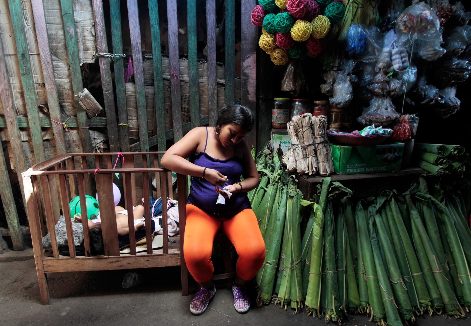 A woman sells banana leaves at a market in Managua, Nicaragua.