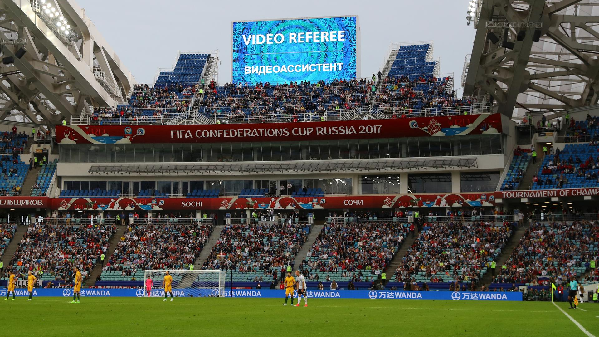 Players waiting for a decision after the referee asked for a video review of Australia's second goal against Germany during a Confederation Cup match in Sochi, Russia