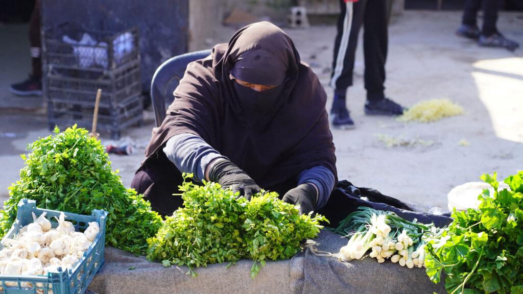 A woman sells herbs at the market in al-Hol camp in northern Syria.
