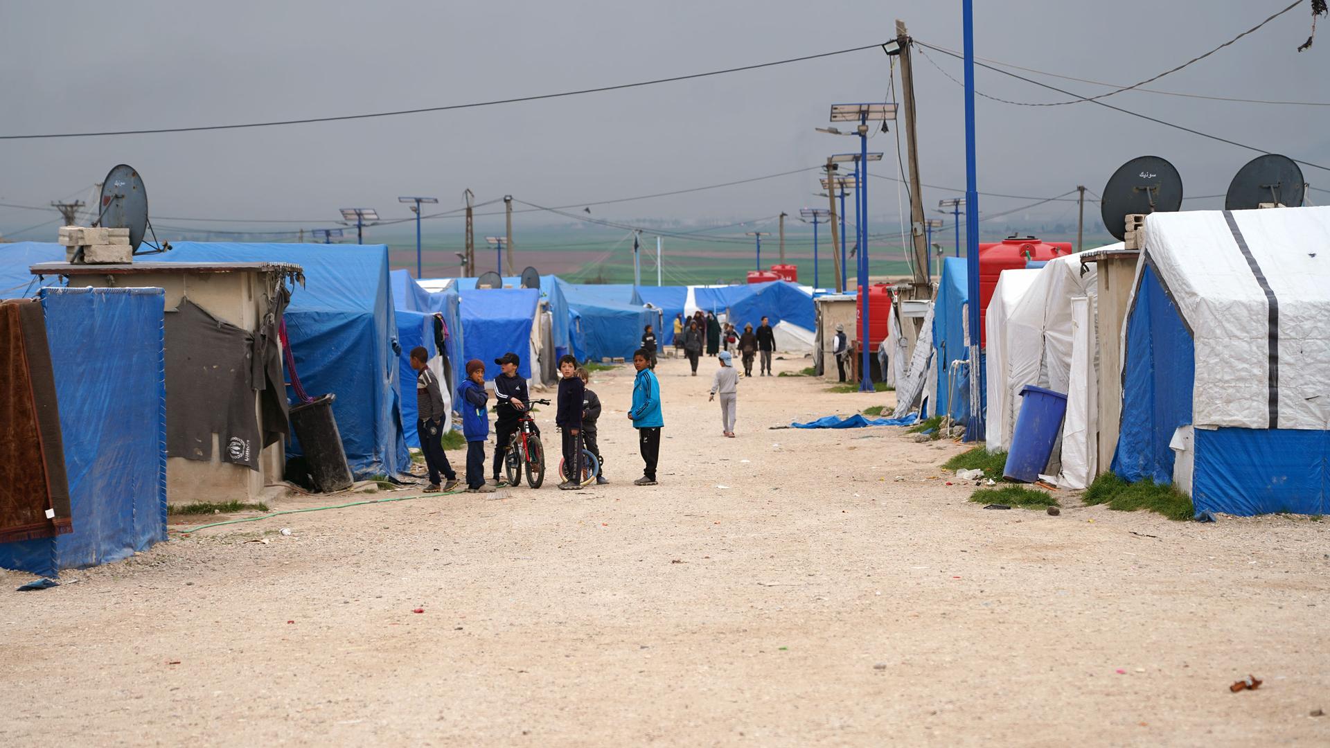 Children stand outside tents at Roj detention camp in northern Syria.