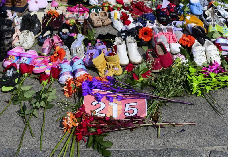 Flowers, children's shoes and other items rest at a memorial