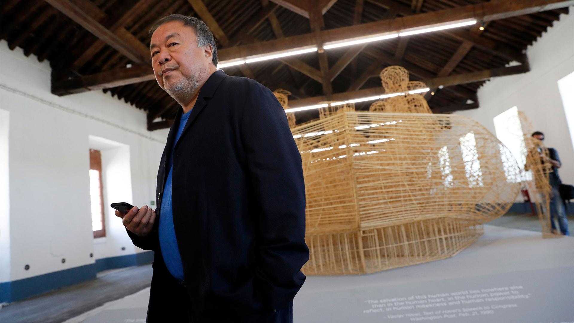 Dissident Chinese artist Ai Weiwei walks by his work "Life Cycle", a migrants' boat made of bamboo, during a press preview of his new exhibition "Rapture" in Lisbon, Portugal