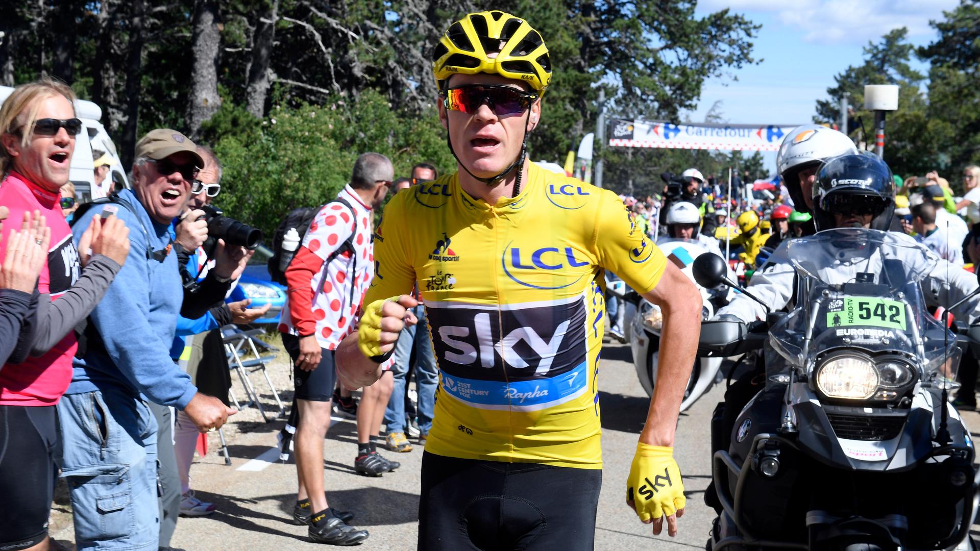 Yellow jersey leader Team Sky rider Chris Froome of Britain runs on the road after a fall.