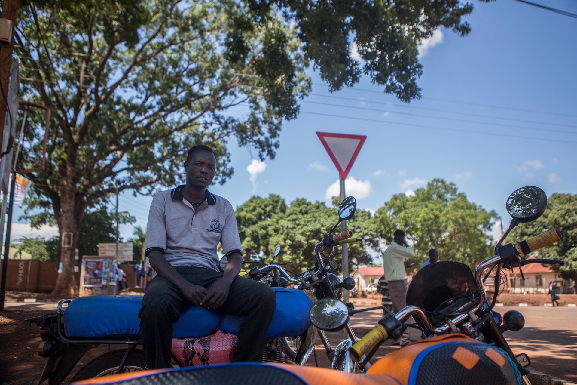 Kenneth Banya rests at the motorcycle taxi stop.