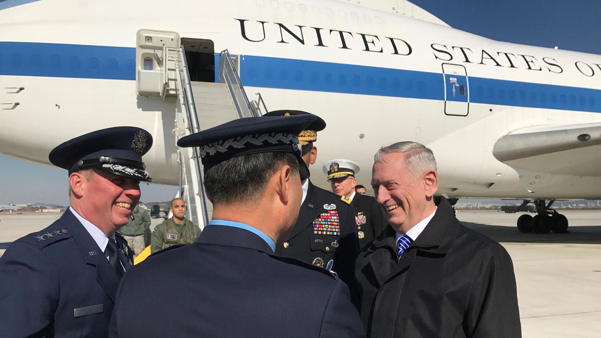 US Defense Secretary Mattis stands on a tarmac in front of a US airplane and talks with military men in uniform