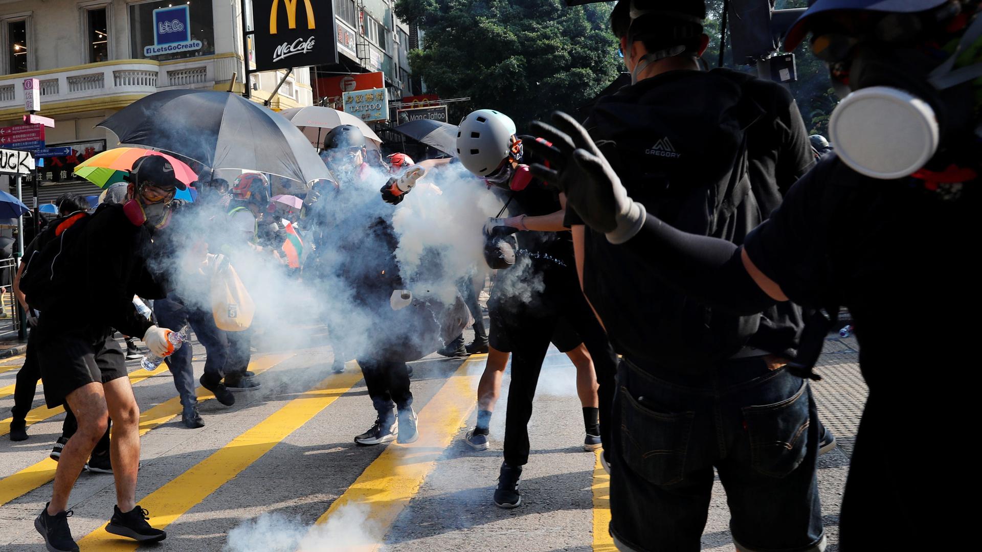 An anti-government protester hits by a tear gas canister during a protest march in Hong Kong, China, on Oct. 20, 2019.