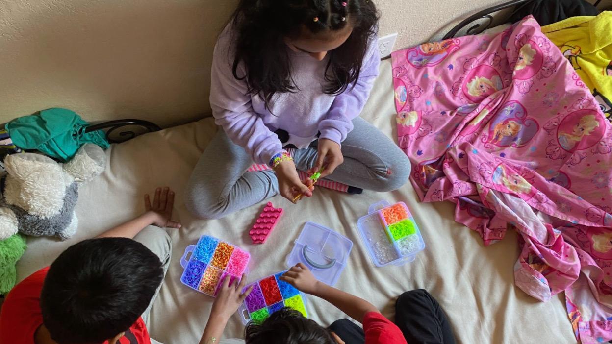 Dinora Hernandez’s three children make bracelets at home in Oakland, California. Every Tuesday, Hernandez heads to a local food bank, assistance that allows her to wire cash to family in El Salvador.
