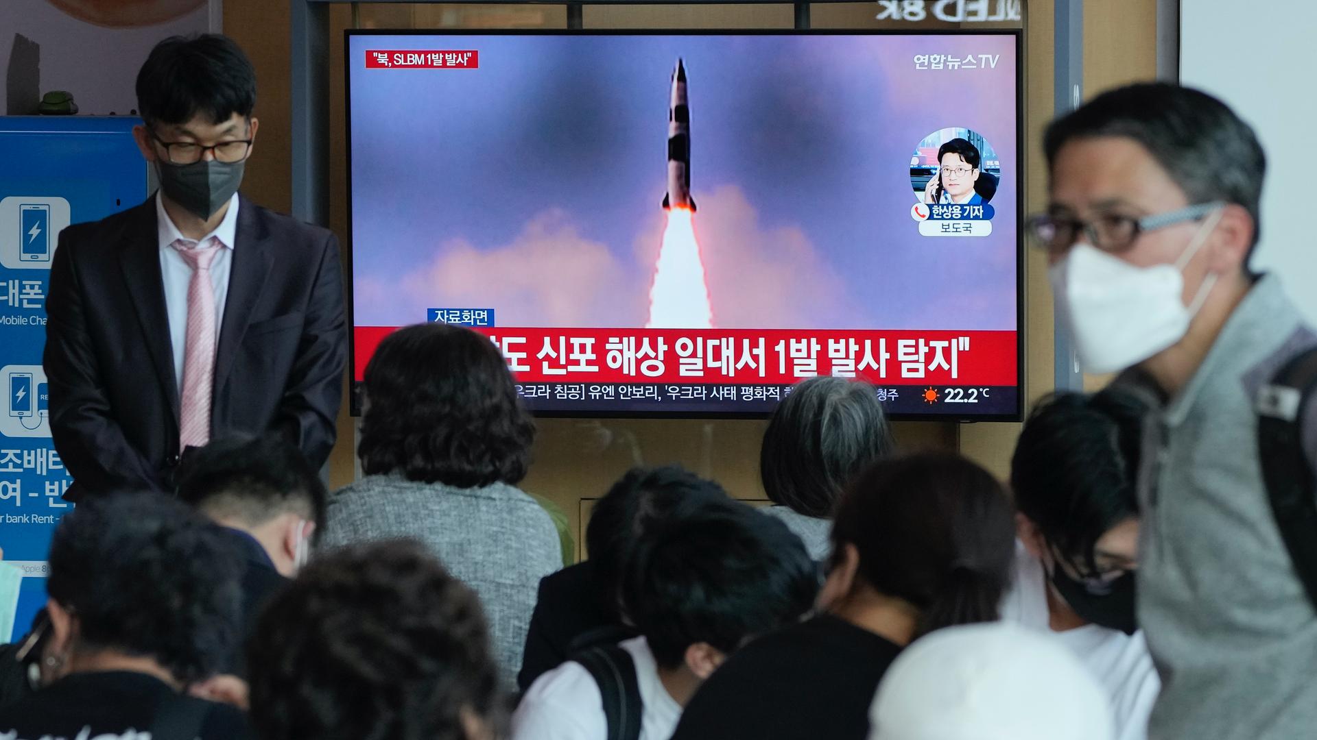 People watch a TV showing a file image of North Korea's missile launch during a news program at the Seoul Railway Station in Seoul, South Korea, May 7, 2022.
