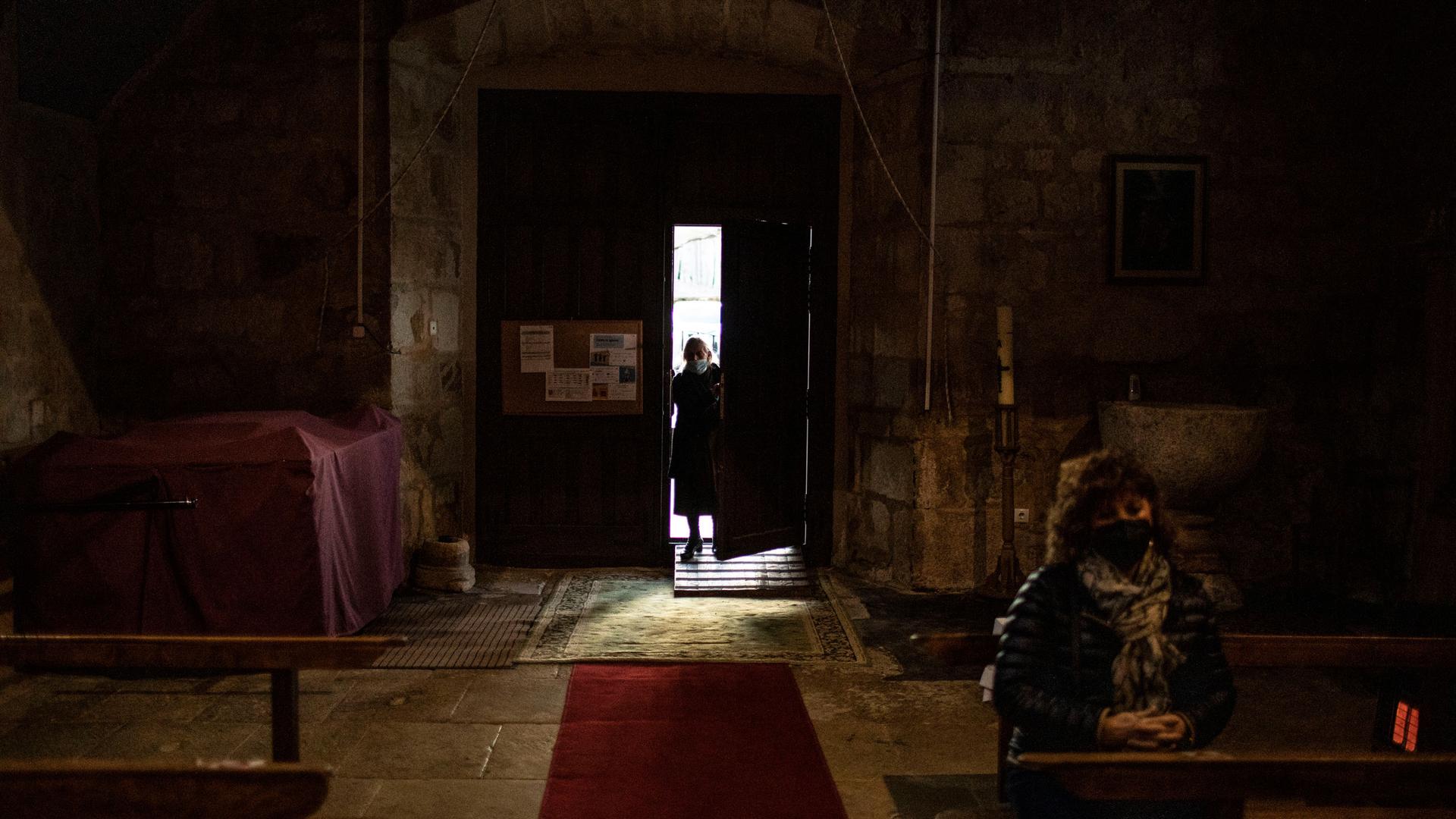 A parishioner enters into the Catholic church of Cazurra, a village of around 75 inhabitants, in the Zamora province of Spain, Saturday, Nov. 27, 2021.