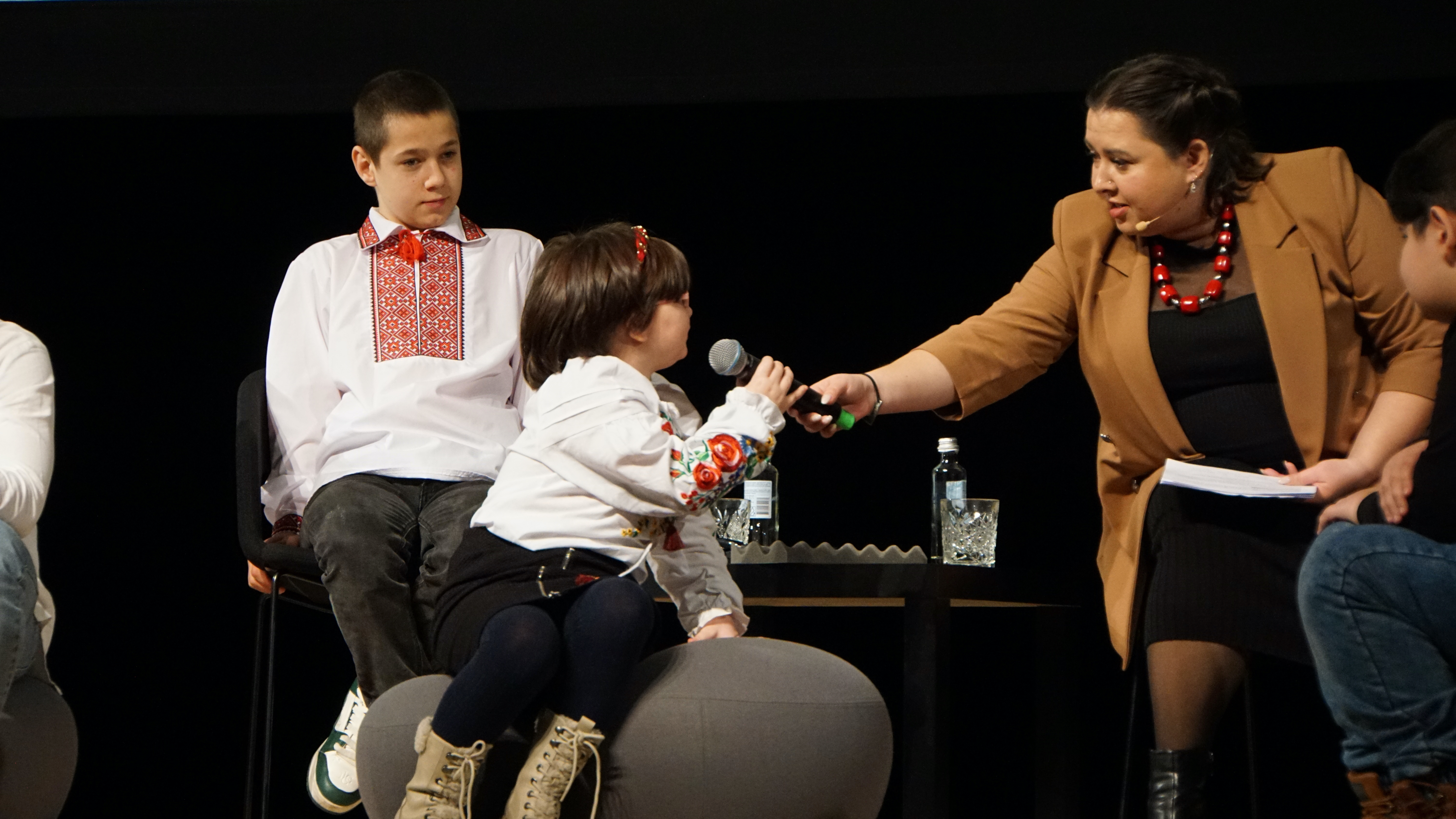 children and woman with a mic onstage