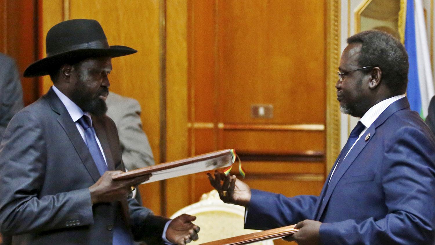 South Sudan's rebel leader Riek Machar, at right, and South Sudan's President Salva Kiir exchange signed peace agreement documents in Addis Ababa in May 2014. 
